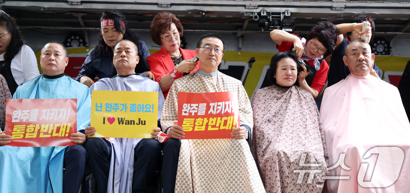 (완주=뉴스1) 유경석 기자 = 25일 전북 완주군 완주군청 앞에서 유의식 완주군의장을 비롯한 의원들이 완주-전주 통합 반대 삭발식을 하고 있다. 2025.6.25/뉴스1