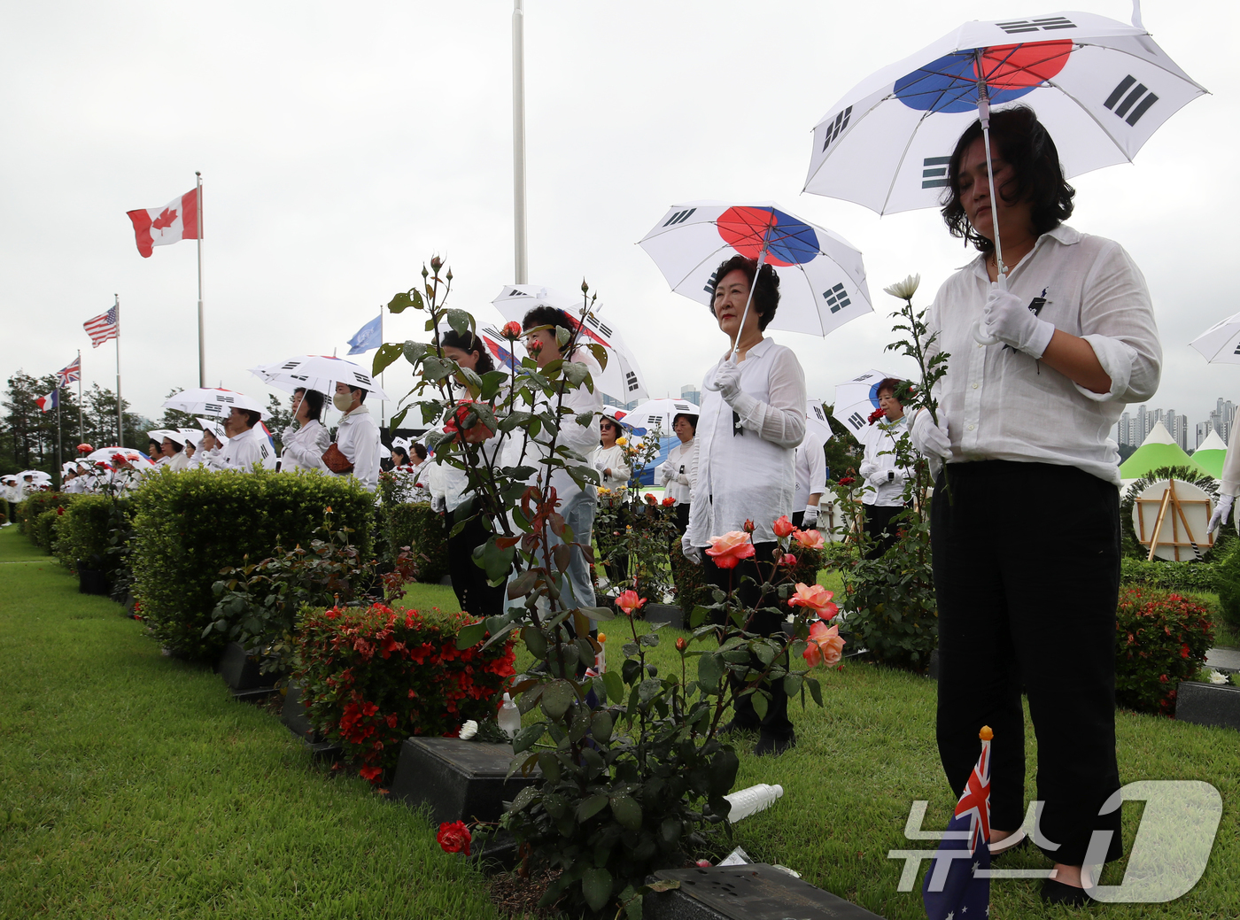 (부산=뉴스1) 윤일지 기자 = 25일 부산 남구 유엔기념공원에서 열린 제75주년 6·25전쟁 참전 유엔전몰용사 추모제에서 태극기 우산을 쓴 참석자들이 유엔군 전몰장병 묘역을 참배 …