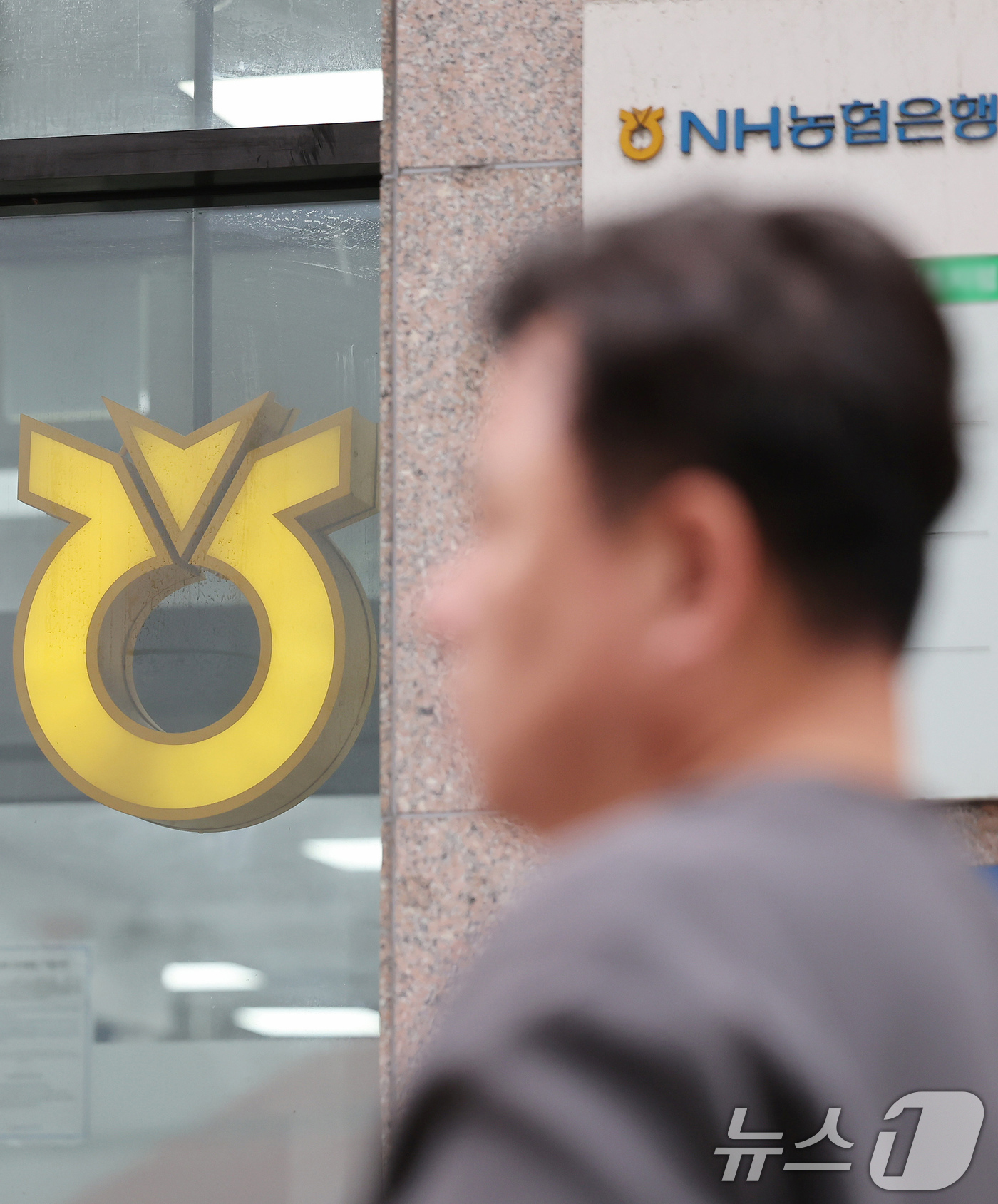 (서울=뉴스1) 장수영 기자 = 25일 서울 시내에 위치한 NH농협은행 앞으로 시민이 지나가고 있다.농협은행은 가계대출 총량 관리를 위해 이날부터 주택담보대출 모기지 보험(MCI· …