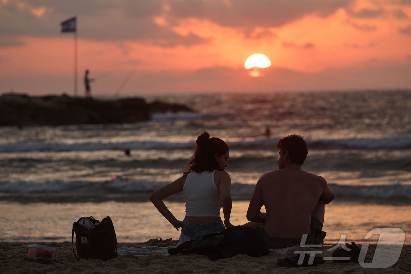 (텔아비브 AFP=뉴스1) 김예슬 기자 = 24일(현지시간) 이스라엘과 이란 간 휴전이 시작된 가운데 이스라엘 텔아비브 해변에 커플이 앉아 있다. 25.06.24ⓒ AFP=뉴스1