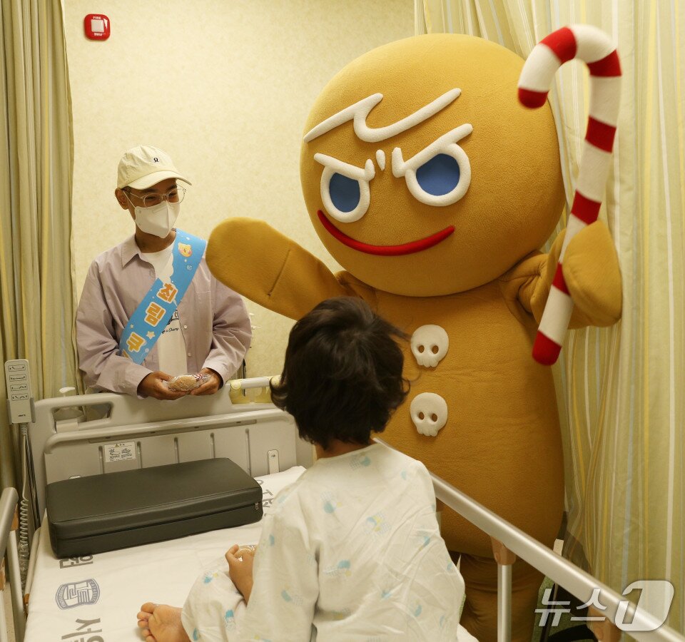 본문 이미지 - 백혈병 환아 최림(왼쪽)이 서울성모병원 골수검사실에서 검사를 기다리는 환아에게 캐릭터 인형을 전달하고 있다.(가톨릭대학교 서울성모병원 제공)