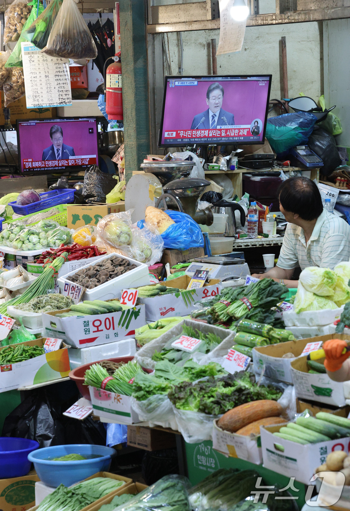 (서울=뉴스1) 신웅수 기자 = 26일 오전 서울 서대문구 인왕시장에서 상인들이 이재명 대통령의 국회 추가경정예산(추경)안 관련 시정연설을 시청하고 있다. 2025.6.26/뉴스1 …