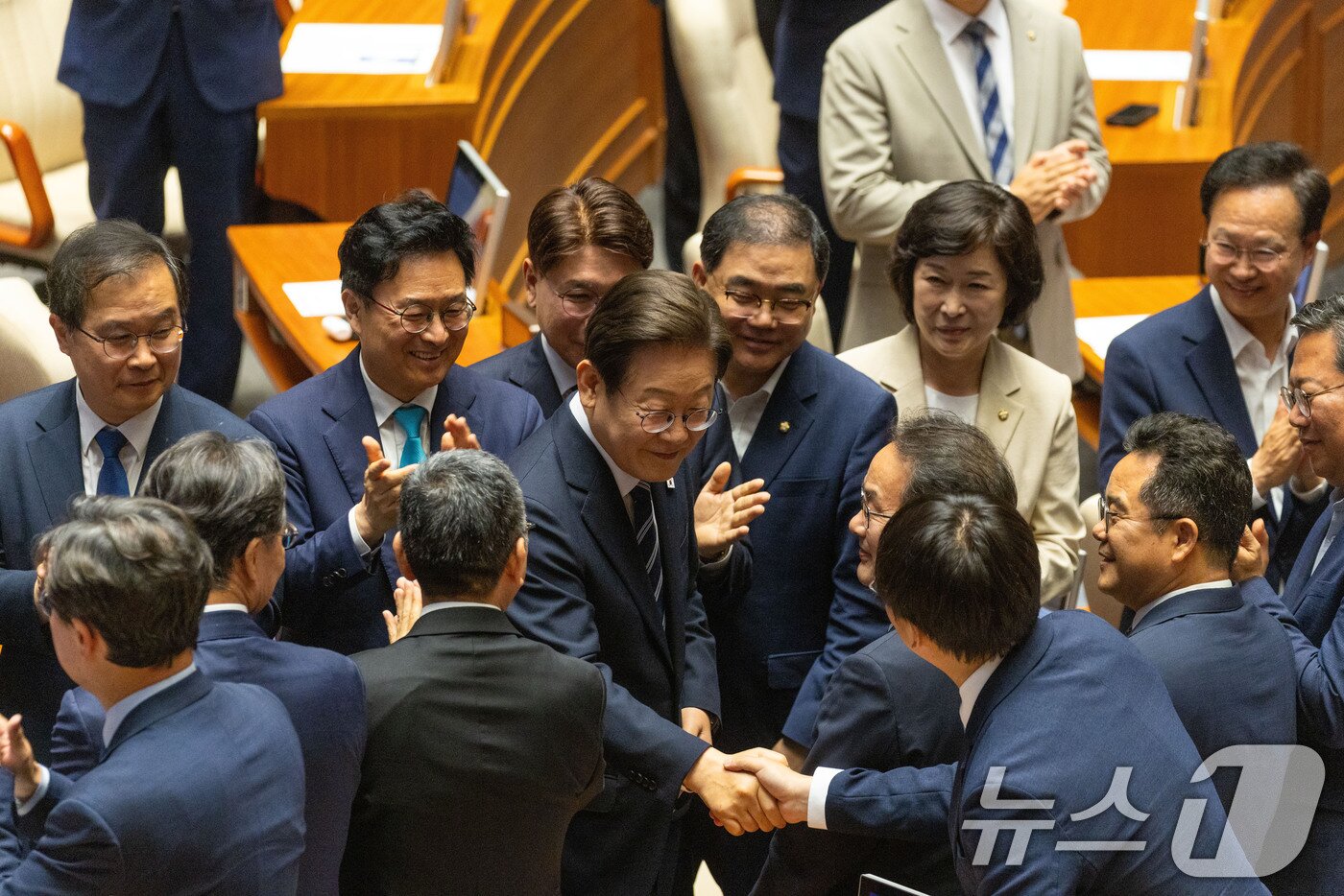본문 이미지 - 이재명 대통령이 26일 국회 본회의장에서 2025년도 제2회 추가경정예산안에 대한 정부의 시정연설을 하기 위해 본회의장으로 입장하며 더불어민주당 의원들과 인사를 나누고 있다. 2025.6.26/뉴스1 ⓒ News1 국회사진기자단