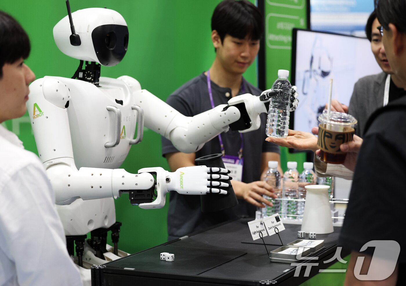 본문 이미지 - 지난 6월 26일 서울 강남구 코엑스에서 막을 올린 &#39;넥스트라이즈 2025&#39;에서 에이로봇의 이족보행 휴머노이드 로봇 엘리스4가 참관객들에게 생수를 건네고 있다. 2025.6.26/뉴스1 ⓒ News1 오대일 기자