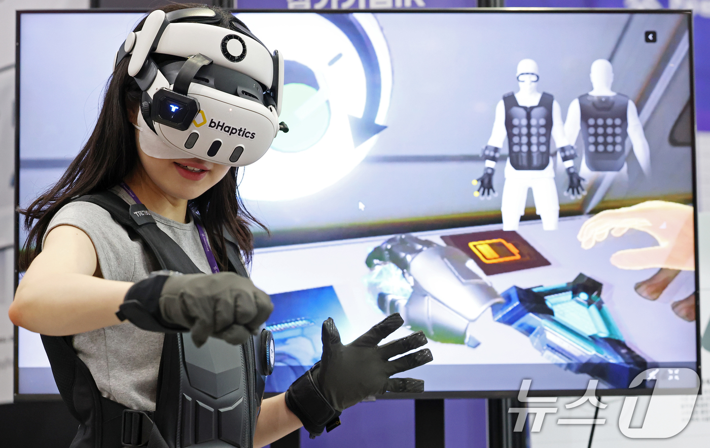 (서울=뉴스1) 오대일 기자 = 26일 서울 강남구 코엑스에서 막을 올린 '넥스트라이즈 2025' 비햅틱스 부스에서 한 여성이 햅틱 피드백 글러브를 끼고 VR 체험을 하고 있다.넥 …
