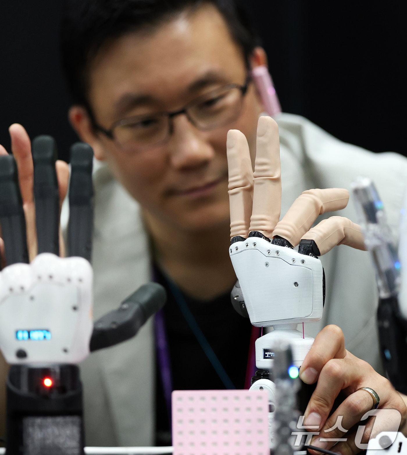 (서울=뉴스1) 오대일 기자 = 26일 서울 강남구 코엑스에서 막을 올린 '넥스트라이즈 2025'에서 만드로 부스 관계자가 상지절단장애인용 전자 의수 및 로봇 손을 시연하고 있다. …