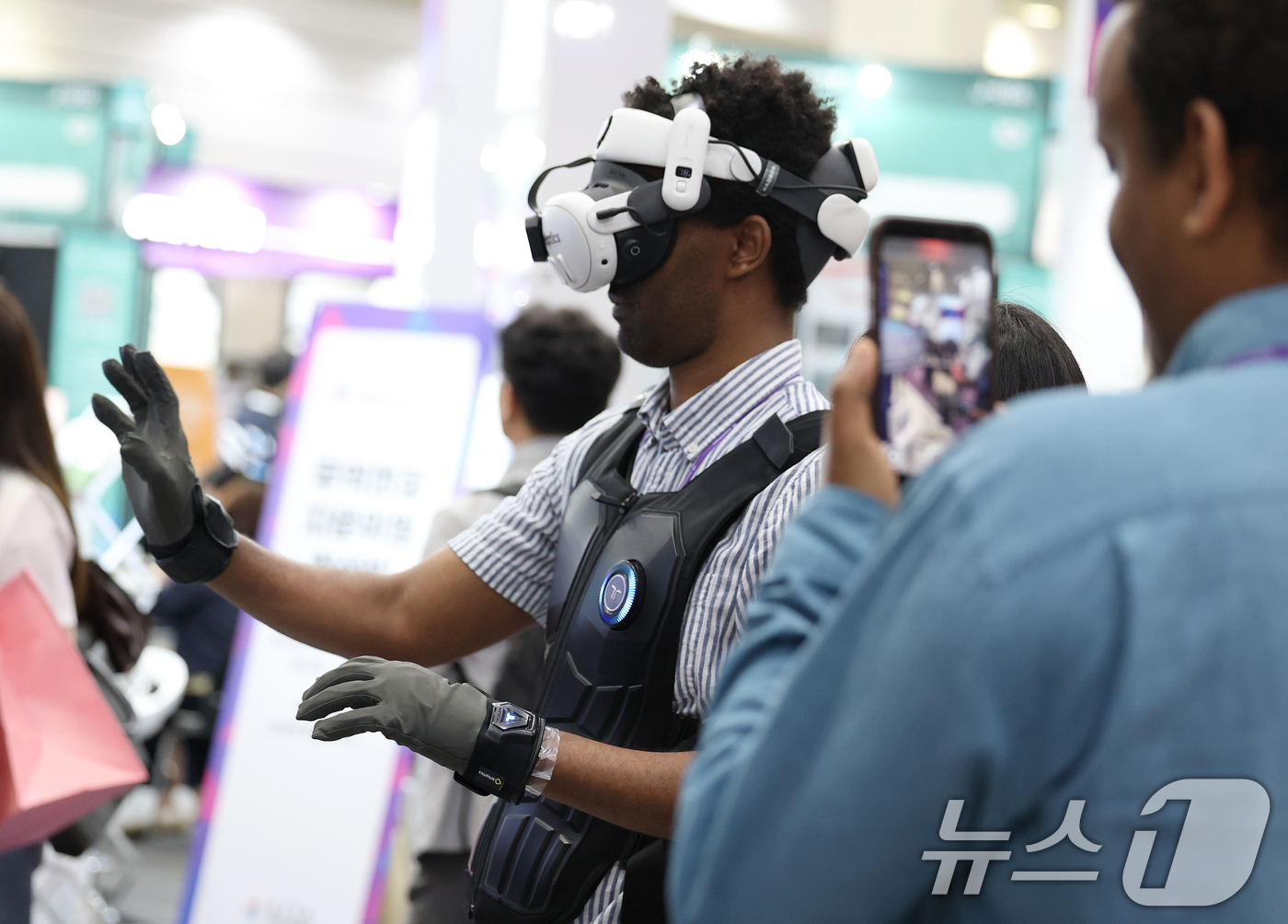 (서울=뉴스1) 오대일 기자 = 26일 서울 강남구 코엑스에서 막을 올린 '넥스트라이즈 2025'에서 외국인 방문객들이 햅틱 웨어러블 기기를 착용한 채 VR 체험을 하고 있다.넥스 …