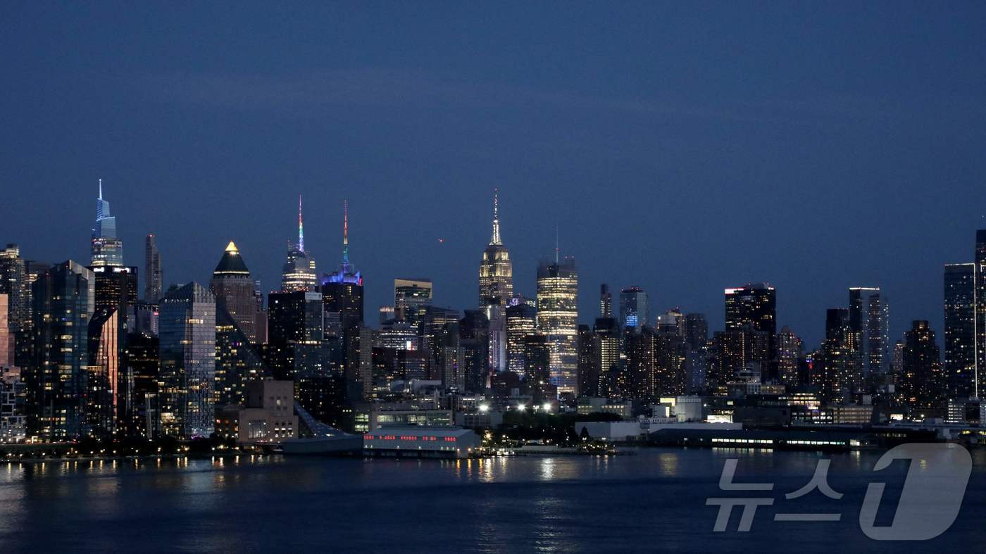 (뉴욕 AFP=뉴스1) 권영미 기자 = 24일(현지시간) 미국 뉴저지주 위호켄에서 바라본 뉴욕 맨해튼 스카이라인 위로 태양이 지고 있다.2025.06.24.ⓒ AFP=뉴스1