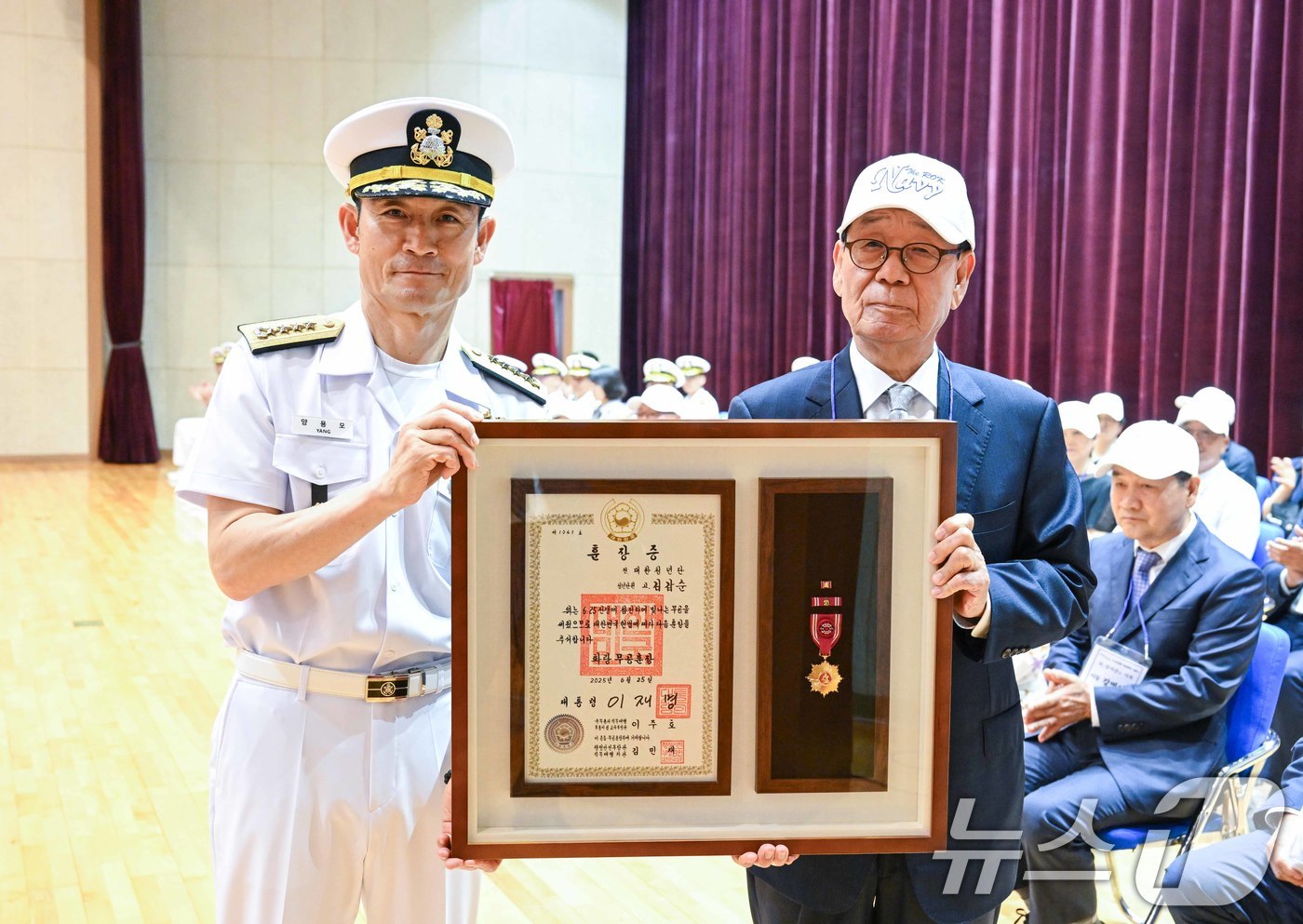 (서울=뉴스1) = 26일 충남 계룡시 해군본부에서 거행된 6·25전쟁 무공훈장 서훈식에서 양용모 해군참모총장이 대한청년단 고 김갑순 단원의 아들인 김상태씨에게 화랑무공훈장을 전도 …
