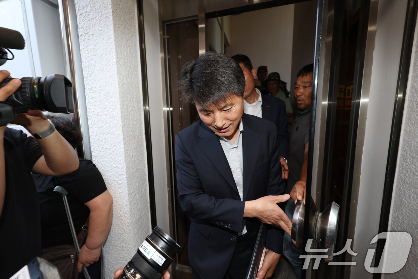 본문 이미지 - 광주 자원회수시설 최종 입지 선정을 앞두고 26일 오후 광주 광산구 삼도동 행정복지센터에서 열린 자원회수시설 주민 설명회에서 주민들이 계단을 점거하고 반발하면서 광주시 관계자가 현장을 빠져 나오고 있다. 2025.6.26/뉴스1 ⓒ News1 이승현 기자