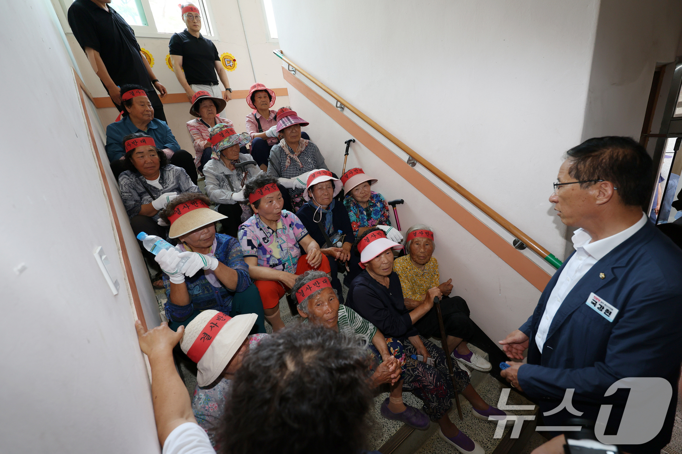 (광주=뉴스1) 이승현 기자 = 광주 자원회수시설 최종 입지 선정을 앞두고 26일 오후 광주 광산구 삼도동 행정복지센터에서 열린 자원회수시설 주민 설명회에서 주민들이 계단을 점거하 …