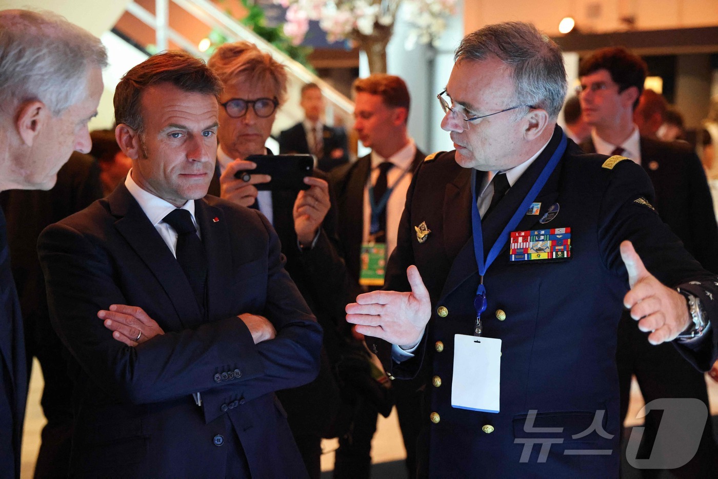 (헤이그 AFP=뉴스1) 이지예 객원기자 = 에마뉘엘 마크롱 프랑스 대통령(왼쪽)이 25일(현지시간) 네덜란드 헤이그에서 열린 나토 정상회의에서 군 관계자와 대화하고 있다. 202 …