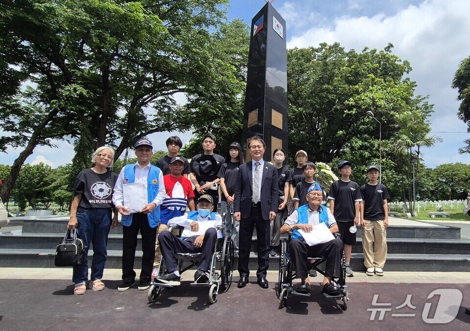 본문 이미지 - 필리핀 한국전 참전용사 기념행사에 참석한 천태초등학교 학생들이 필리핀 참전용사들에게 &#39;한국전 참전용사 티셔츠&#39;를 전달한 뒤 함께 기념사진을 찍고 있다. &#40;전남도교육청 제공, 재판매 및 DB 금지&#41;/뉴스1 