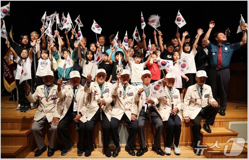 본문 이미지 - 강진 도암초등학교 학생들이 참전용사 할아버지들과 함께 태극기를 흔들며 기념사진을 찍고 있다.&#40;전남도교육청 제공, 재판매 및 DB 금지&#41;/뉴스1 