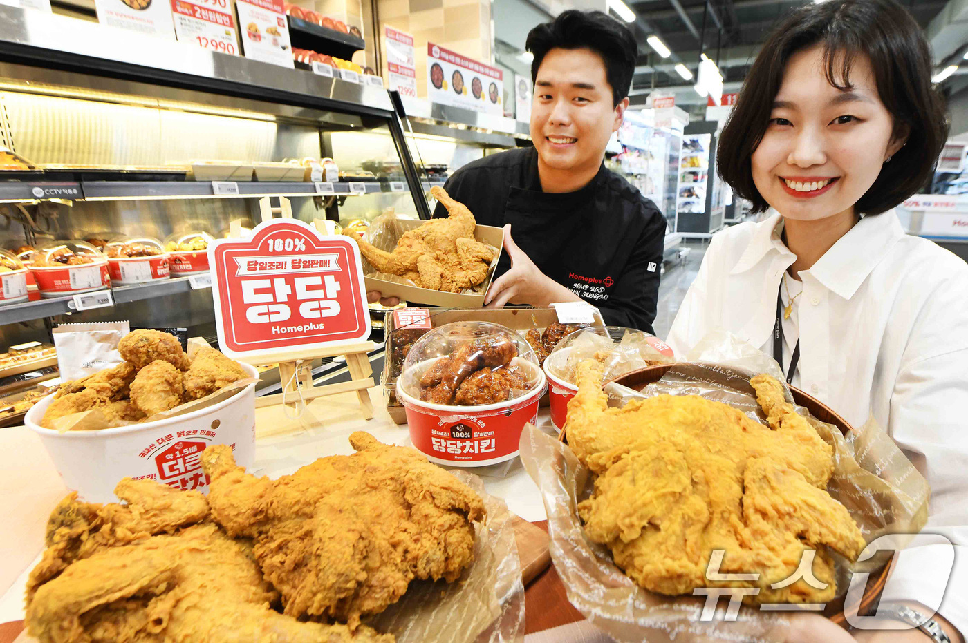 (서울=뉴스1) = 윤성민 홈플러스 델리사업팀 핫델리 담당 개발자(왼쪽)와 김태경 바이어가 29일 서울 '홈플러스 메가 푸드 마켓 라이브' 강서점에서 당당치킨 3주년을 기념해 '당 …