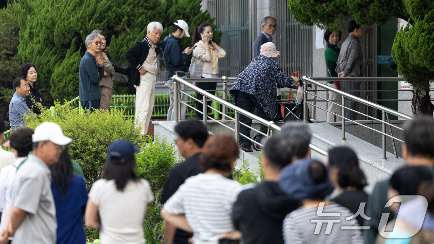 (서울=뉴스1) 이승배 기자 = 제21대 대통령 선거일인 3일 서울 영등포구 여의도 윤중중학교에 마련된 투표소를 찾은 유권자들이 길게 줄 서 있다. 2025.6.3/뉴스1