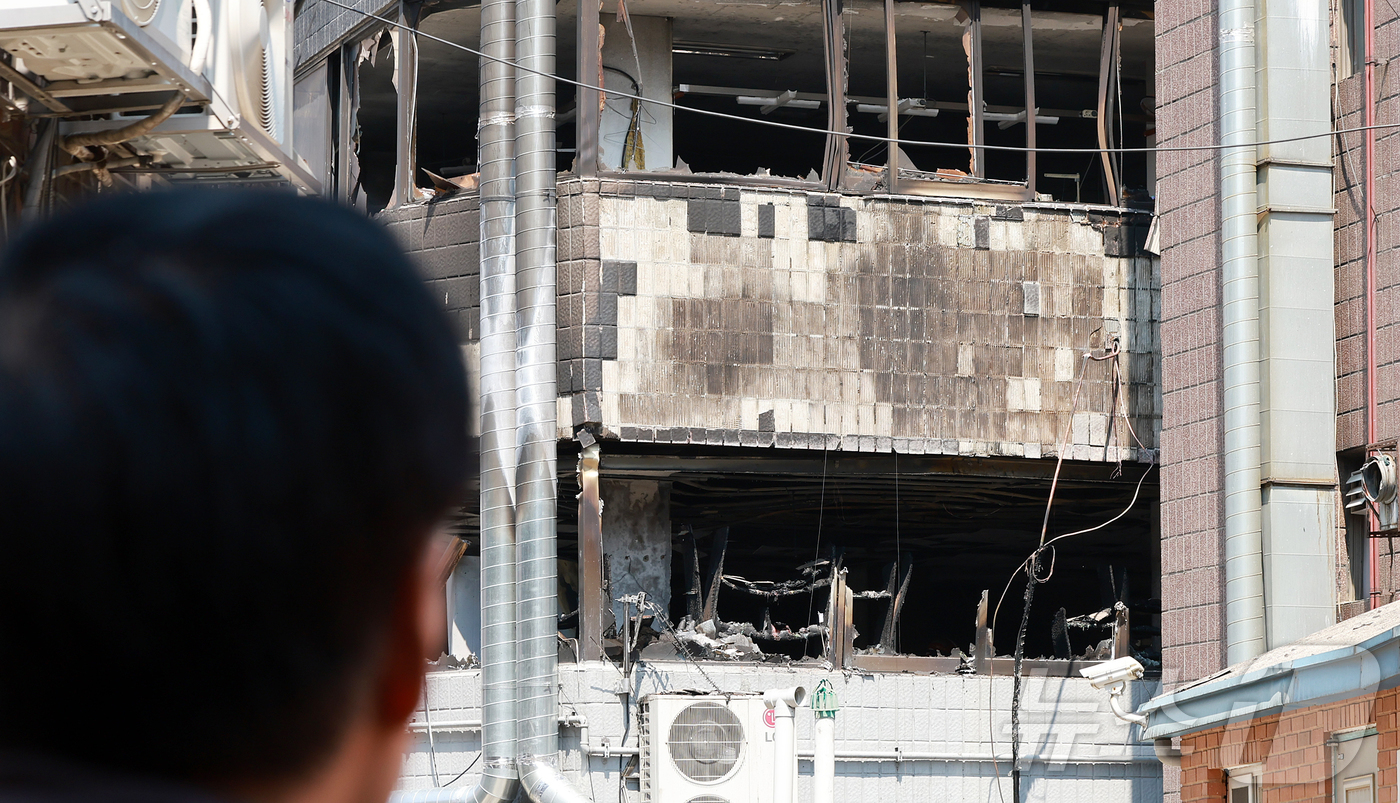 (서울=뉴스1) 김진환 기자 = 3일 오전 한 시민이 화재가 발생한 서울 중구 신당동의 한 봉제공장을 바라보고 있다.소방당국은 이날 오전 9시 35분께 서울 중구 신당동의 5층 규 …