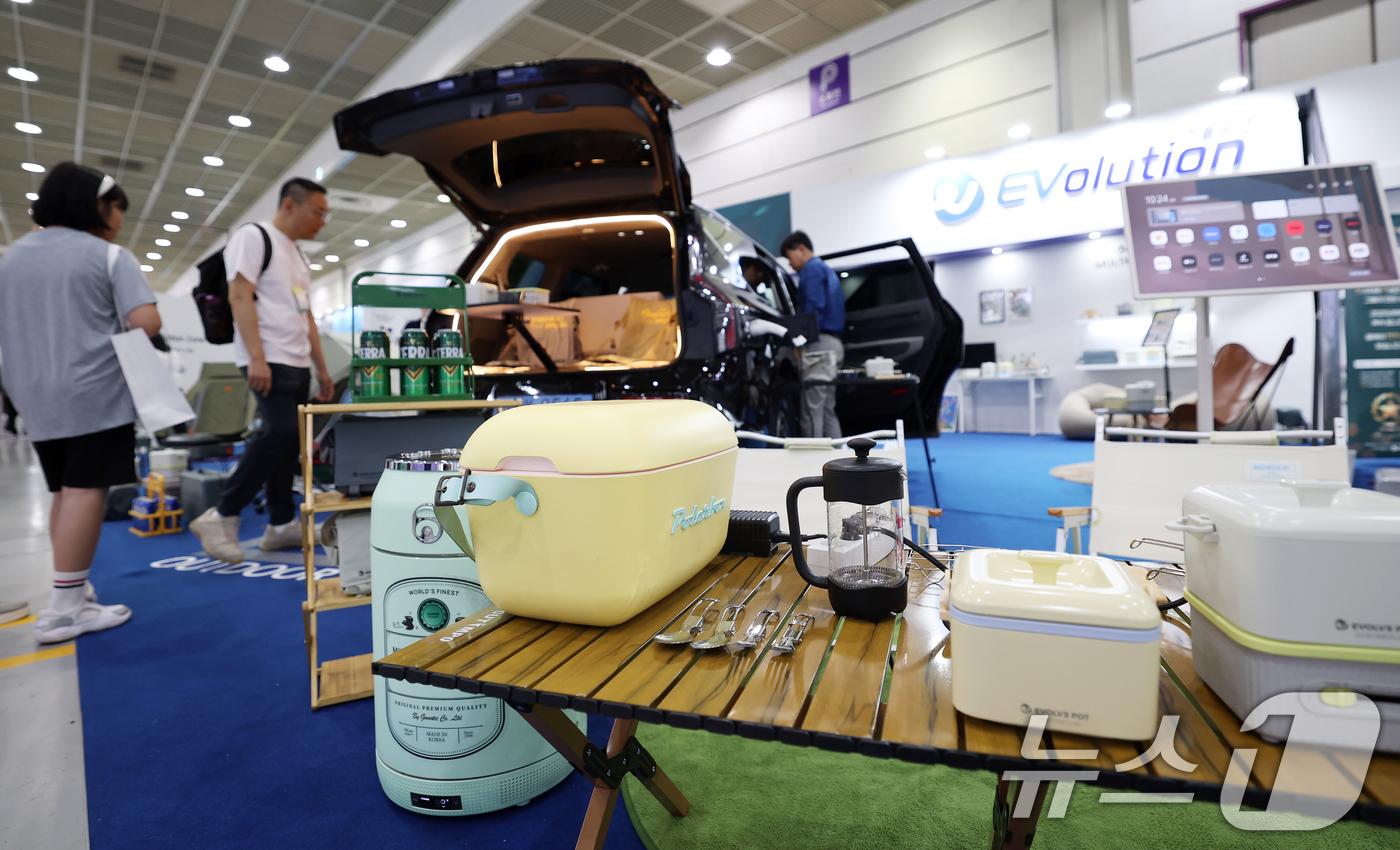 (서울=뉴스1) 오대일 기자 = 3일 오전 서울 강남구 코엑스에서 열린 'EV트렌드코리아 2025'에서 방문객들이 전기차 V2L 기능을 활용한 아웃도어 활용 사례를 살펴보고 있다. …