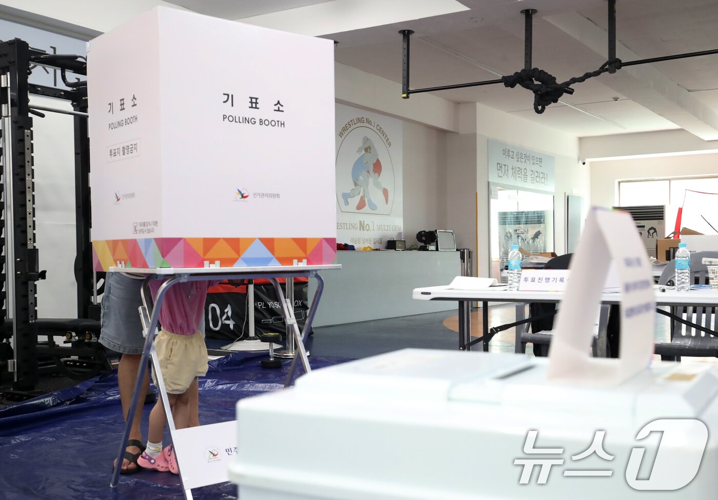 본문 이미지 - 제21대 대통령 선거일인 3일 부산 수영구 레슬링넘버원 멀티짐에 마련된 남천제2동 제3투표소에서 유권자가 아이와 함께 투표를 하고 있다. 2025.6.3/뉴스1 ⓒ News1 윤일지 기자