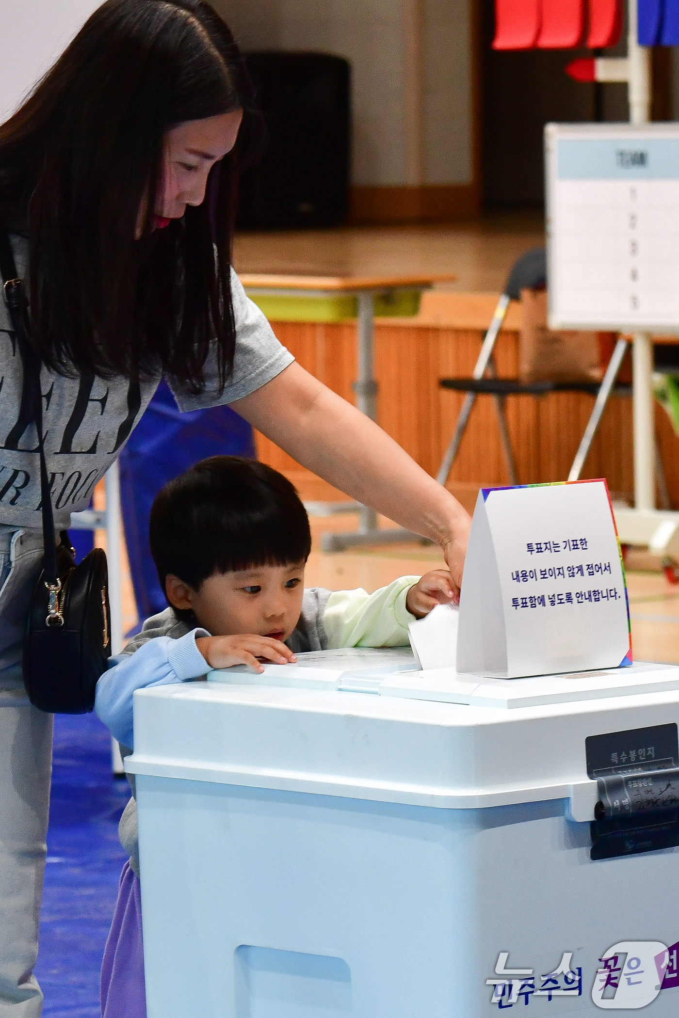 (포항=뉴스1) 최창호 기자 = 제21대 대통령 선거일인 3일 경북 포항시 남구 오천읍 문덕초등학교에 마련된 투표소에서 어린이가 엄마와 함께 투표용지를 기표함에 넣고 있다. 202 …