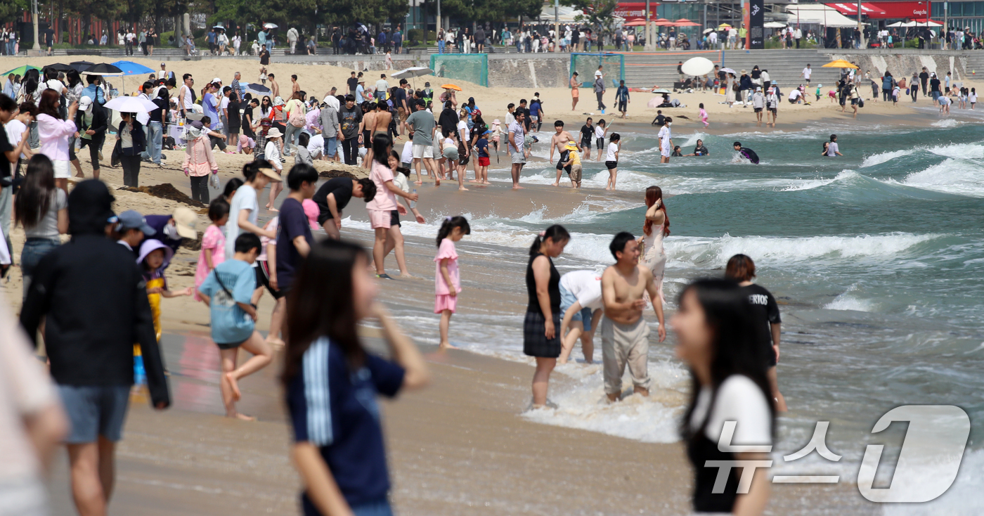 (부산=뉴스1) 윤일지 기자 = 제21대 대통령 선거일이자 초여름 날씨를 보인 3일 오후 부산 해운대해수욕장을 찾은 시민, 관광객 등이 물놀이를 즐기며 더위를 식히고 있다. 202 …