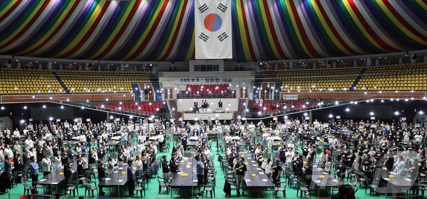 (제주=뉴스1) 오미란 기자 = 제21대 대통령 선거일인 3일 오후 제주시 개표소인 제주종합경기장 한라체육관에서 개표사무원들이 국기에 대한 경례를 하고 있다. 2025.6.3/뉴스 …