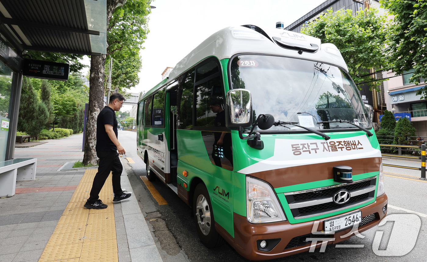 (서울=뉴스1) 박지혜 기자 = 자치구 단위 마을버스 성격의 '지역동행 자율주행버스'가 시범 운행을 시작한 30일 서울 동작구 숭실대 중문 정류소에서 관계자가 시승을 하고 있다.동 …