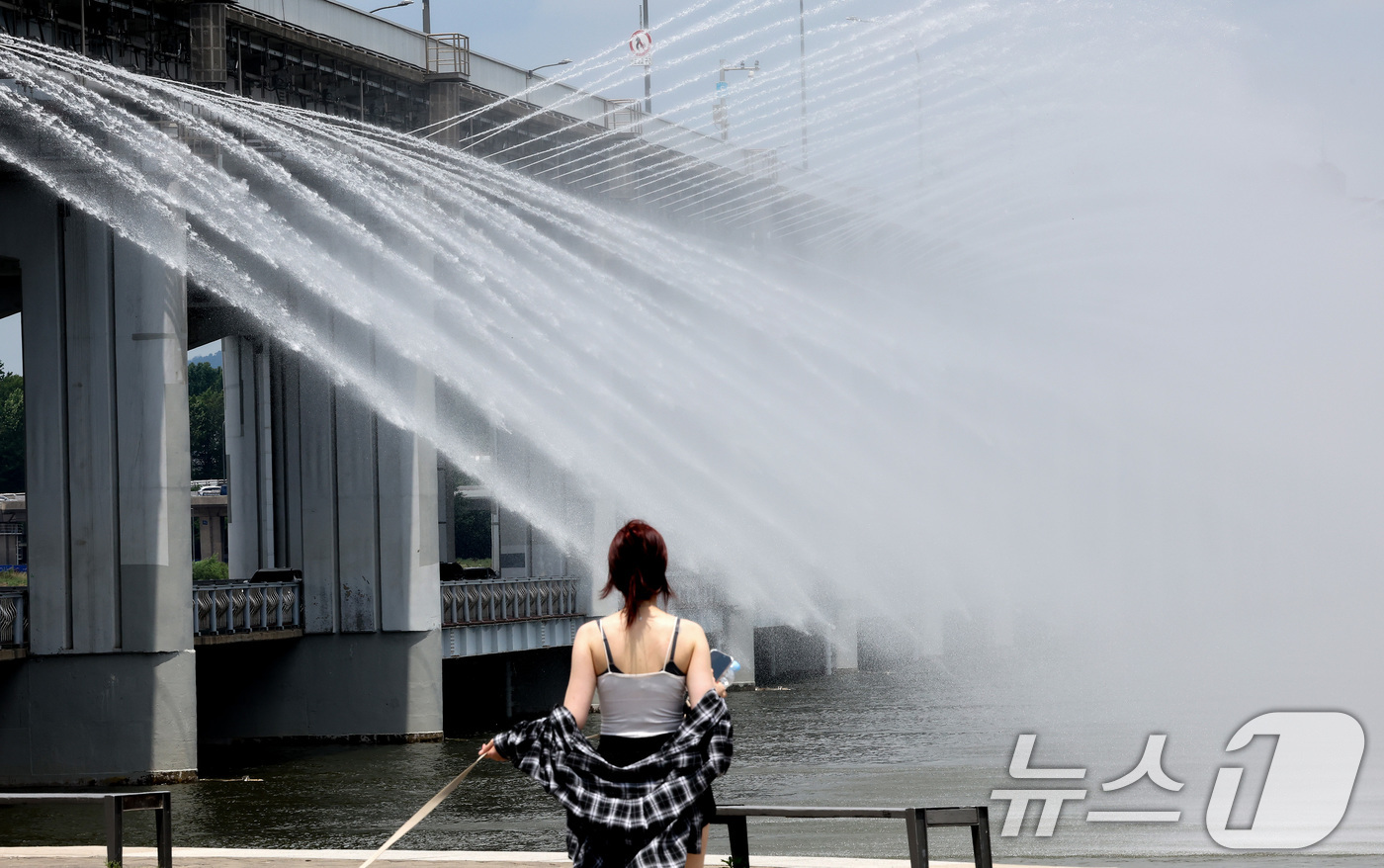 (서울=뉴스1) 이동해 기자 = 서울 전역에 폭염주의보가 발령된 30일 오후 서울 서초구 반포한강공원에서 시민들이 반포대교 달빛무지개분수를 바라보며 더위를 식히고 있다. 2025. …