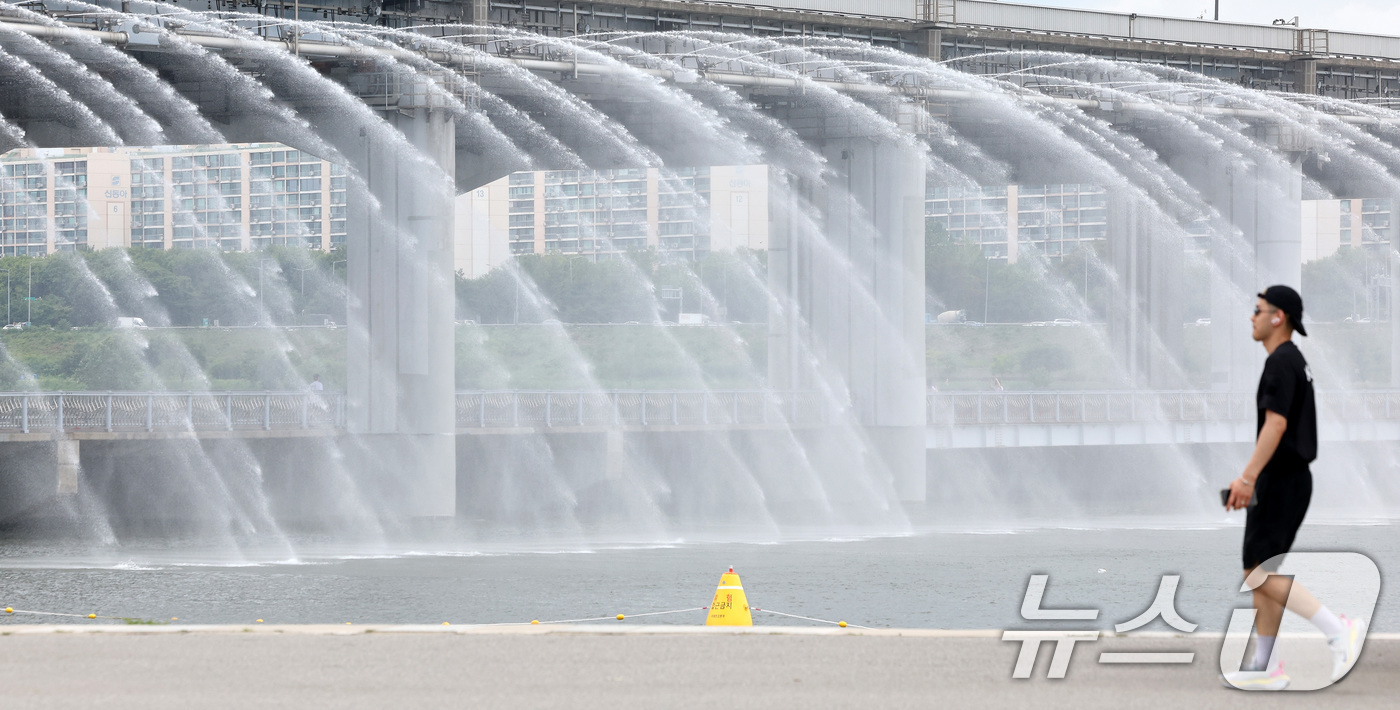 (서울=뉴스1) 이동해 기자 = 서울 전역에 폭염주의보가 발령된 30일 오후 서울 서초구 반포한강공원에서 시민들이 반포대교 달빛무지개분수를 바라보며 산책을 하고 있다. 2025.6 …