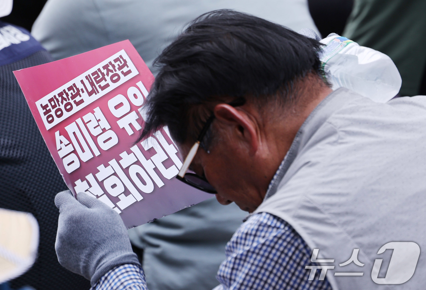 (서울=뉴스1) 박지혜 기자 = 30일 서울 용산구 대통령실 앞에서 전국농민총연맹 주최로 열린 1차 전국농민 결의대회에 참가한 한 농민이 얼음으로 더위를 식히고 있다.이날 전국농민 …