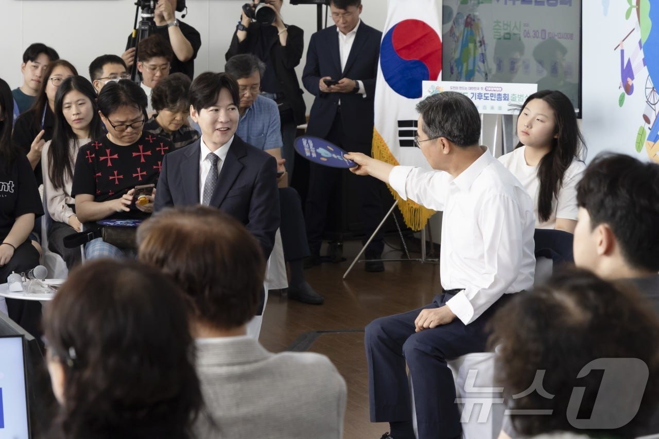 (서울=뉴스1) = 김동연 경기도지사가 30일 경기 시흥에코센터에서 열린 '경기도 도민기후총회'에 참석해 진행자 박찬민 아나운서에게 부채질을 해주고 있다. (경기도 제공. 재판매 …