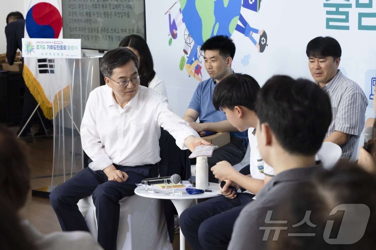 (서울=뉴스1) = 김동연 경기도지사가 30일 경기 시흥에코센터에서 열린 '경기도 도민기후총회'에 참석해 땀을 흘리는 학생 참가자에게 자신의 손수건을 건네고 있다. (경기도 제공. …