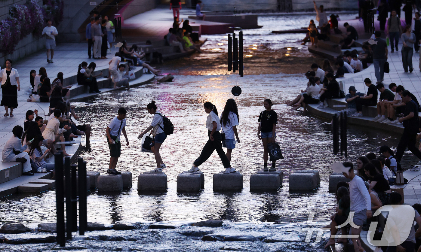 (서울=뉴스1) 박지혜 기자 = 서울에 올해 처음으로 열대야가 기록된 30일 서울 청계천에서 시민들과 외국인 관광객들이 더위를 식히고 있다.열대야는 밤 사이(전날 오후 6시 1분부 …