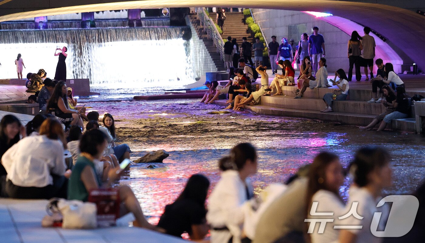 본문 이미지 - 서울에 올해 처음으로 열대야가 기록된 30일 서울 청계천에서 시민들과 외국인 관광객들이 더위를 식히고 있다. 열대야는 밤 사이&#40;전날 오후 6시 1분부터 다음날 오전 9시까지&#41; 기온이 25도 이상으로 유지되는 현상이다. 2025.6.30/뉴스1 ⓒ News1 박지혜 기자