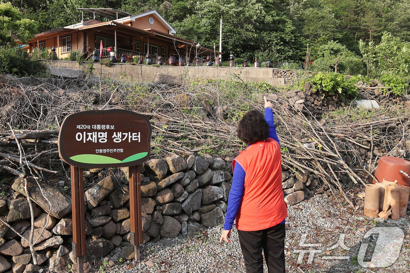 본문 이미지 - 4일 이재명 더불어민주당 대통령 후보의 &#39;당선 확실&#39; 보도가 이어지는 가운데 이 후보의 생가 주민들의 기대감도 높아지고 있다. 사진은 3일 오후 경북 안동시 예안면 도촌리 이재명 후보의 생가터. 지난 대선 때 만들어진 &#39;제20대 대통령후보 이재명 생가터&#39; 안내판 옆에서 한 주민이 주택 아래 생가터를 가리키고 있다. 현재는 밭으로 사용되고 있다. 2025.6.4/뉴스1 ⓒ News1 공정식 기자