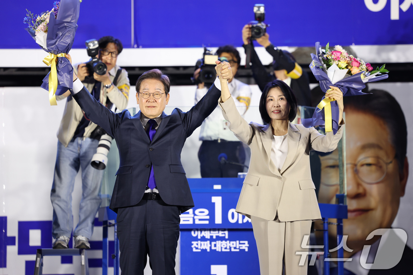 (서울=뉴스1) 안은나 기자 = 당선이 확실시된 이재명 더불어민주당 대통령 후보가 김혜경 여사와 4일 오전 서울 여의도 국회 앞을 찾아 꽃다발을 들어보이고 있다. (공동취재) 20 …