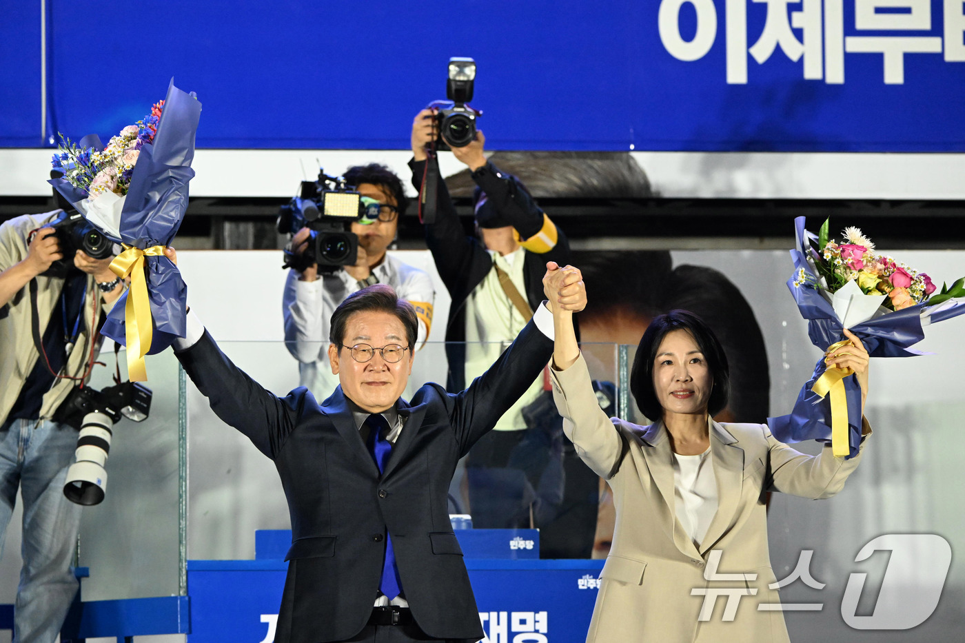 (서울=뉴스1) 안은나 기자 = 당선이 확실시된 이재명 더불어민주당 대통령 후보가 김혜경 여사와 4일 오전 서울 여의도 국회 앞을 찾아 꽃다발을 들어보이고 있다. (공동취재) 20 …