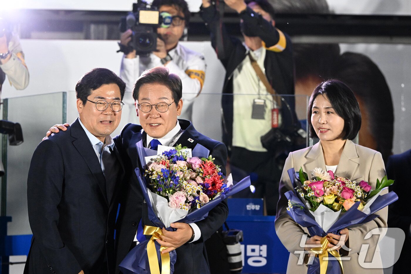 본문 이미지 - 당선이 확실시된 이재명 더불어민주당 대통령 후보가 김혜경 여사와 4일 오전 서울 여의도 국회 앞을 찾아 박찬대 상임총괄선대본부장으로부터 꽃다발을 받고 있다. &#40;공동취재&#41; 2025.6.4/뉴스1 ⓒ News1 안은나 기자