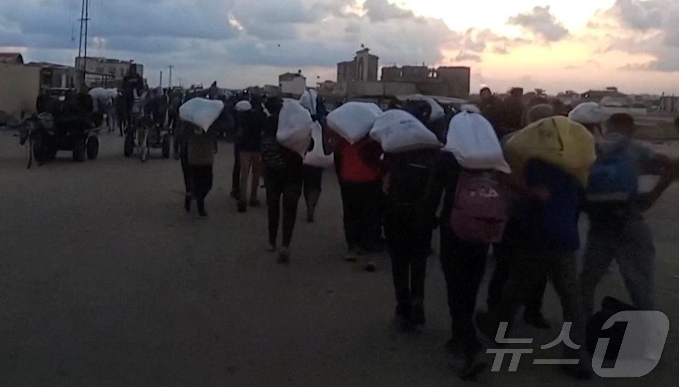 (라파 로이터=뉴스1) 김예슬 기자 = 3일(현지시간) 가자지구 라파에서 구호품을 배급받은 팔레스타인 주민들. 25.06.03ⓒ 로이터=뉴스1