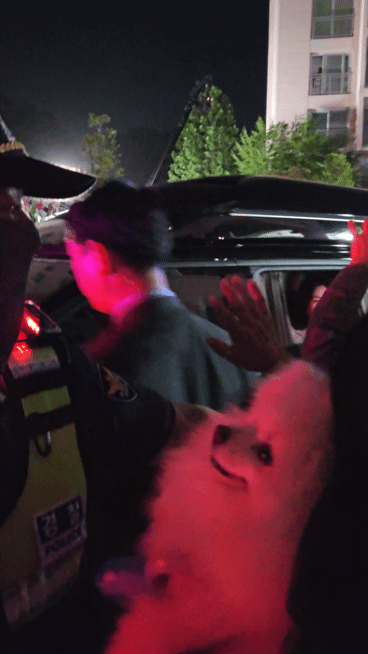 본문 이미지 - 반려견을 안은 시민이 3일 인천 계양구 이재명 대통령 사저 앞에서 김혜경 여사에게 손을 흔들고 있다. ⓒ 뉴스1 최서윤 기자