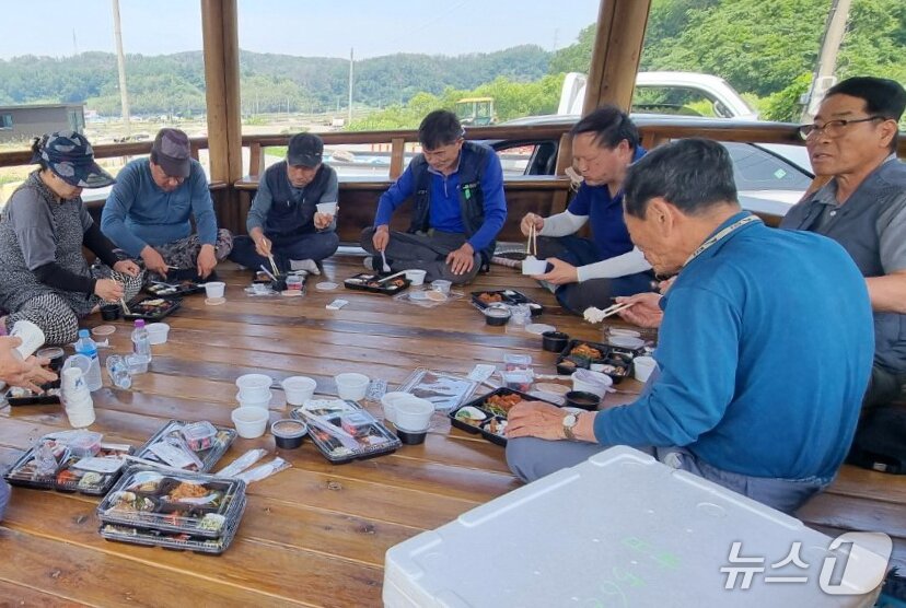 본문 이미지 - 한국수력원자력(주) 월성원자력본부 직원들이 모내기 현장에 새참을 직접 배달한 후 농민들과 함께 나눠 먹고 있다. ( 월성원자력본부제공, 제판매 및 DB 금지) 2025.6.4/뉴스1