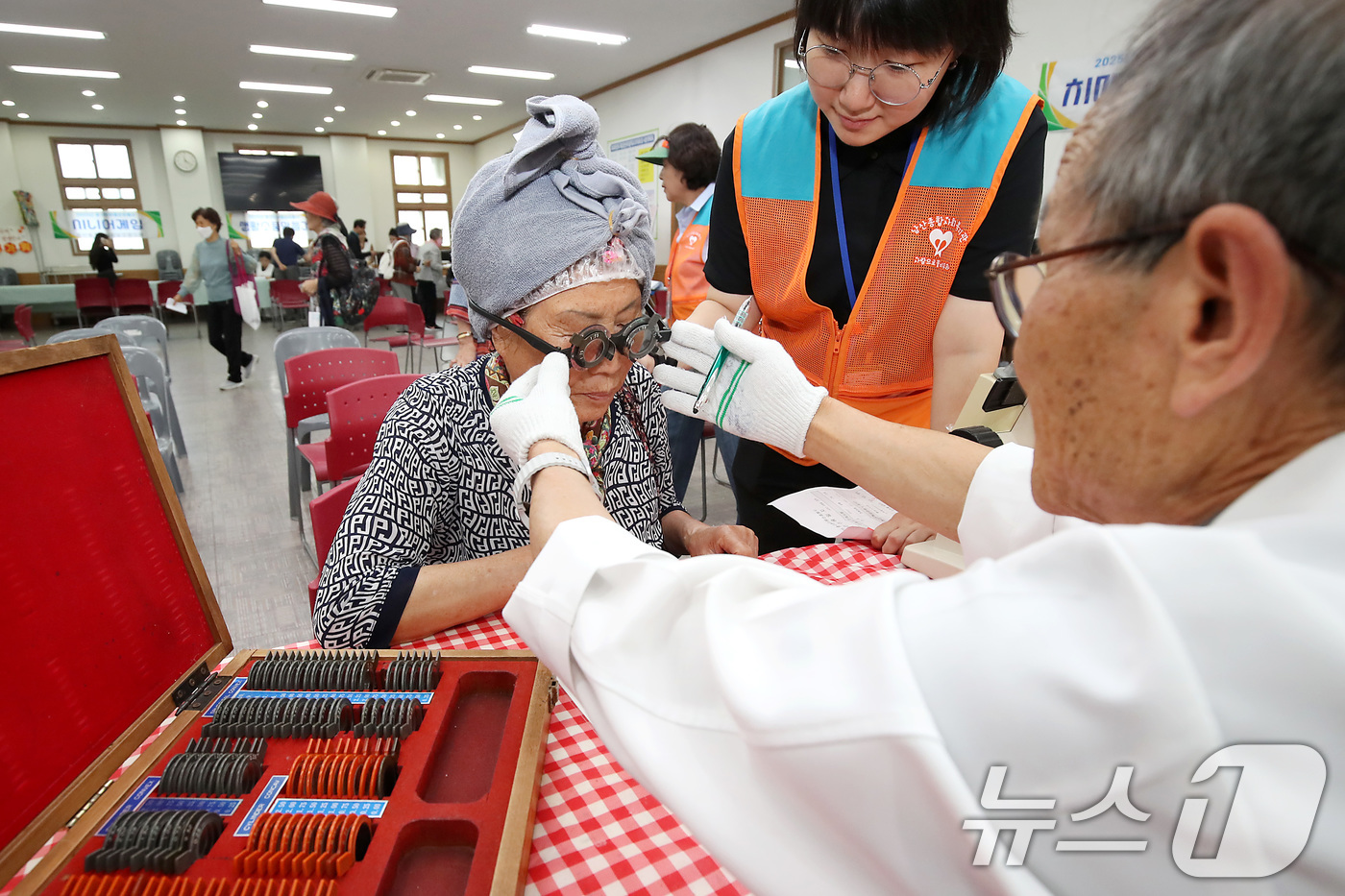 (대구=뉴스1) 공정식 기자 = 5일 오전 대구 중구 서문교회에서 열린 '2025년 제1회 중구 한마음순회봉사' 행사장을 찾은 어르신이 돋보기를 맞추기 위해 시력검사를 받고 있다. …