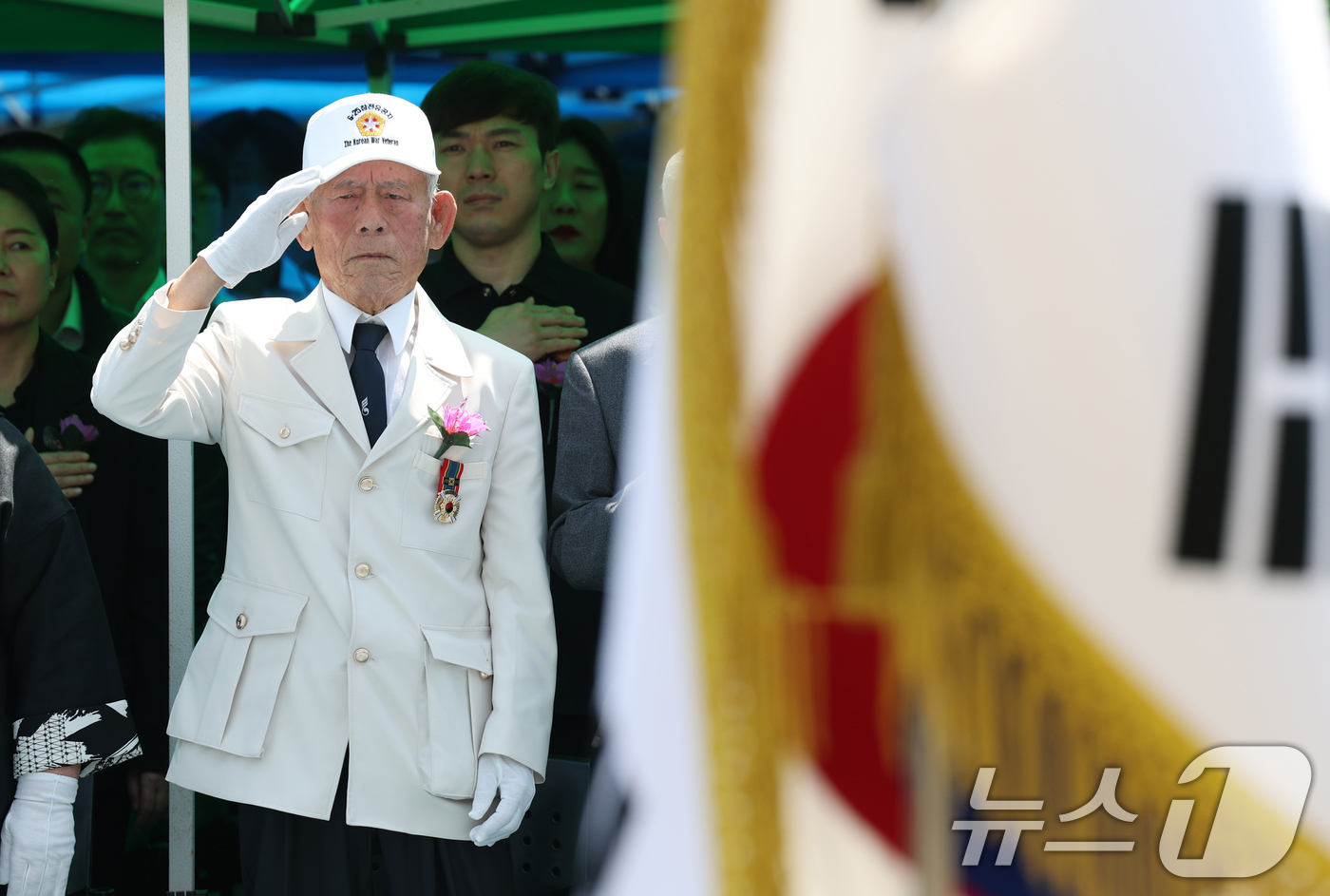 (수원=뉴스1) 김영운 기자 = 현충일을 하루 앞둔 5일 오전 경기 수원시 팔달구 수원고등학교에서 열린 '6.25 참전 동문 추모 헌화식'에서 내빈들이 국기에 대한 경례를 하고 있 …