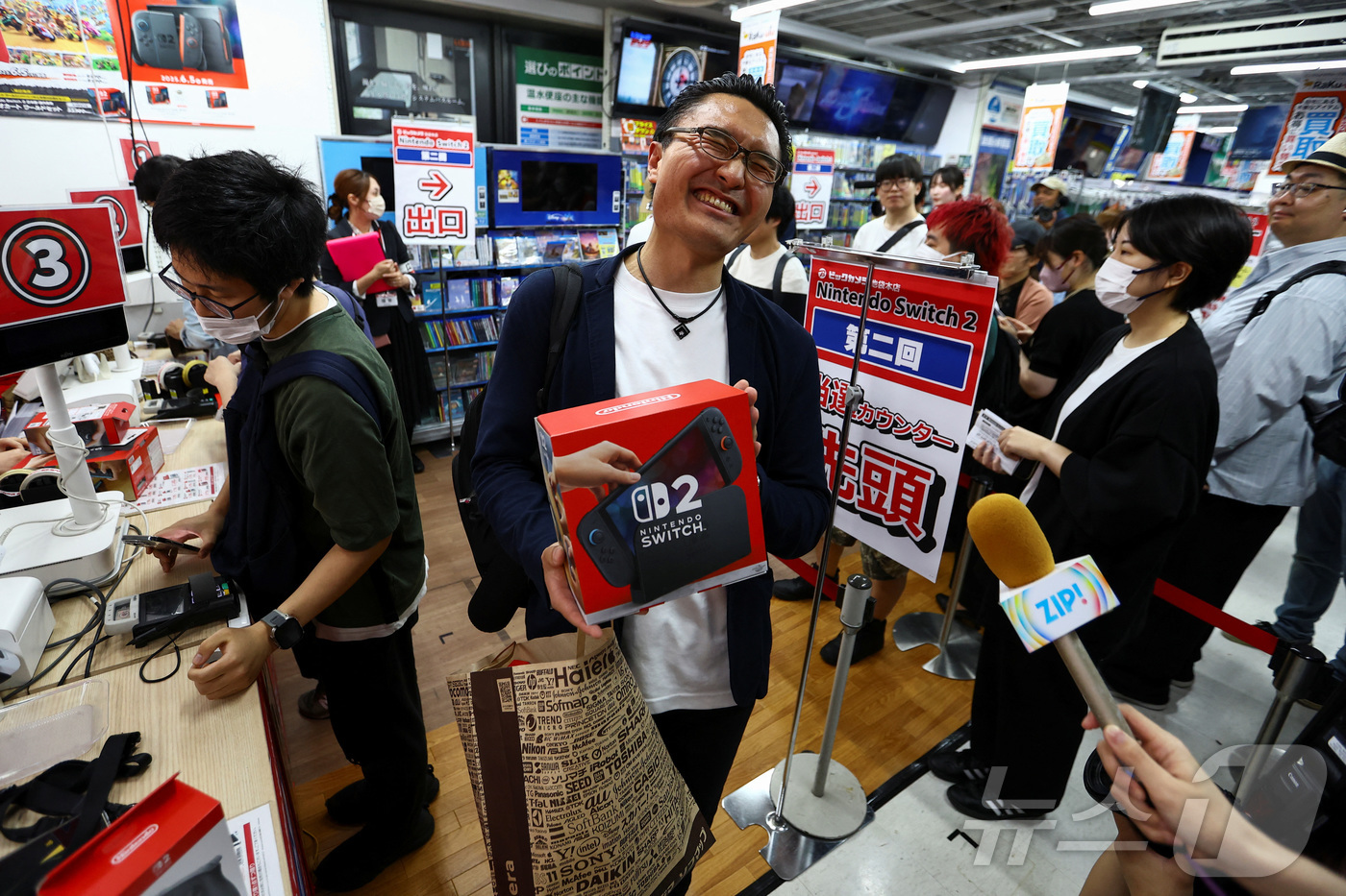 (도쿄 로이터=뉴스1) 최종일 선임기자 = 닌텐도가 전세계에서 스위치 2 판매를 시작한 가운데 5일 일본 도쿄의 한 전자 매장에서 한 고객이 신제품을 구매한 신제품을 듣고 만족스러 …