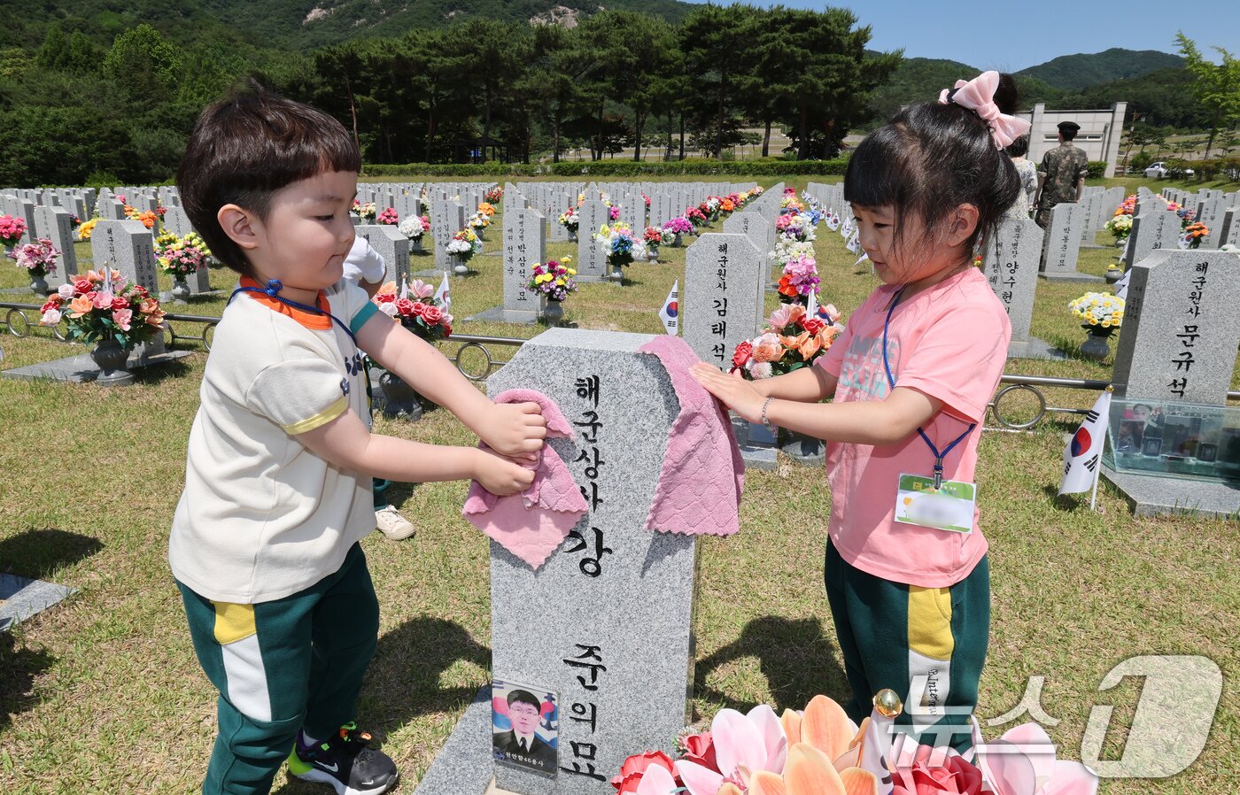 본문 이미지 - 현충일을 하루 앞둔 5일 대전 유성구 국립대전현충원에서 어린이집 원생들이 추모를 마치고 묘비를 닦고 있다. 2025.6.5/뉴스1 ⓒ News1 김기태 기자