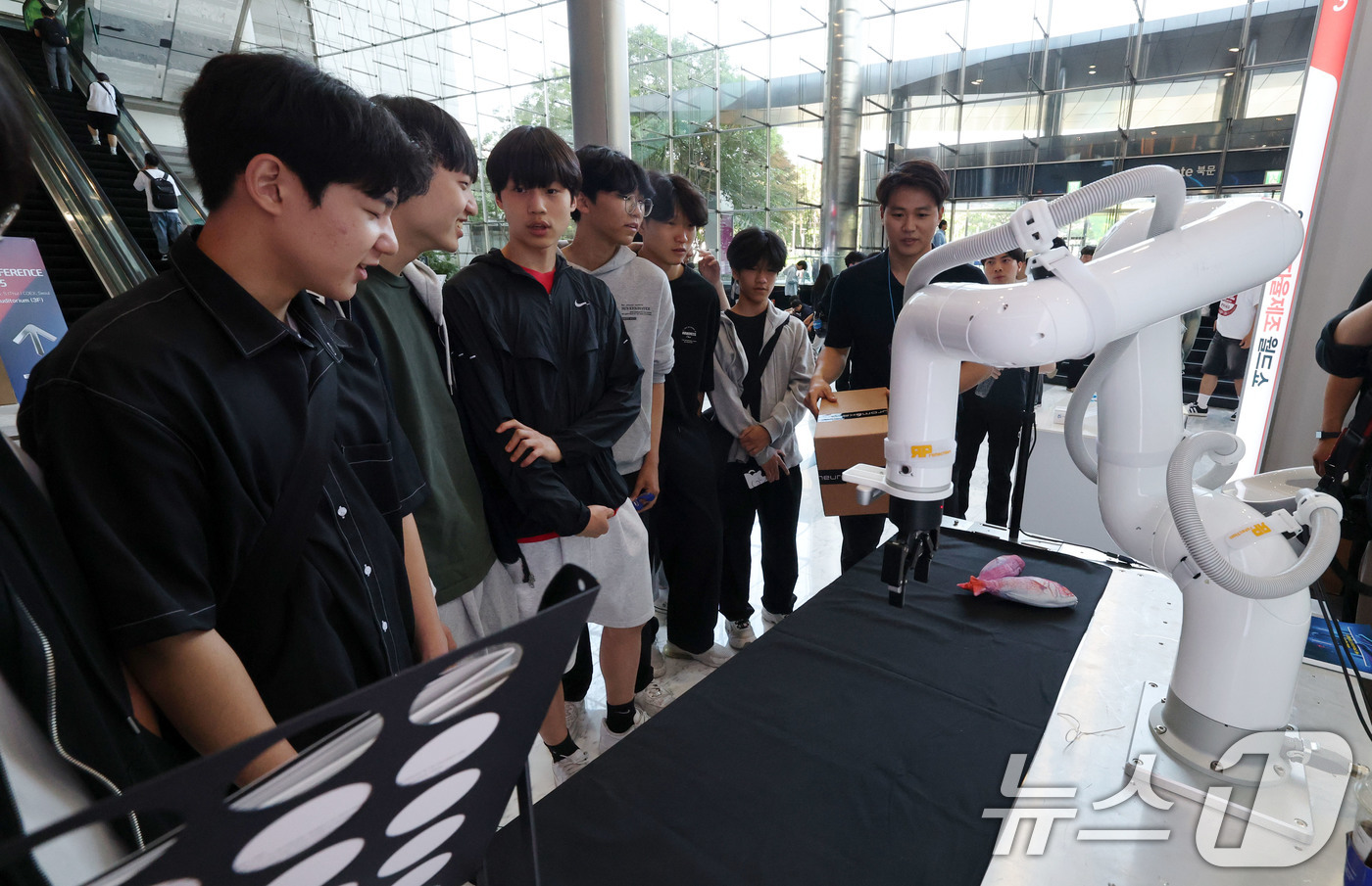(서울=뉴스1) 박세연 기자 = 5일 서울 강남구 코엑스에서 열린 2025 자율제조 월드쇼를 찾은 관람객들이 산업용 협동로봇을 살펴보고 있다.이번 박람회는 스마트 제조솔루션과 인공 …