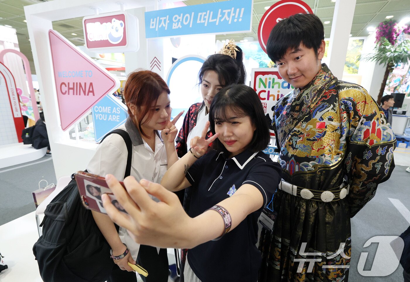 본문 이미지 - 5일 서울 강남구 코엑스에서 열린 제40회 서울국제관광전을 찾은 관람객들이 중국 부스에서 중국 전통복장을 입은 직원들과 기념촬영을 하고 있다. 2025.6.5/뉴스1 ⓒ News1 박세연 기자