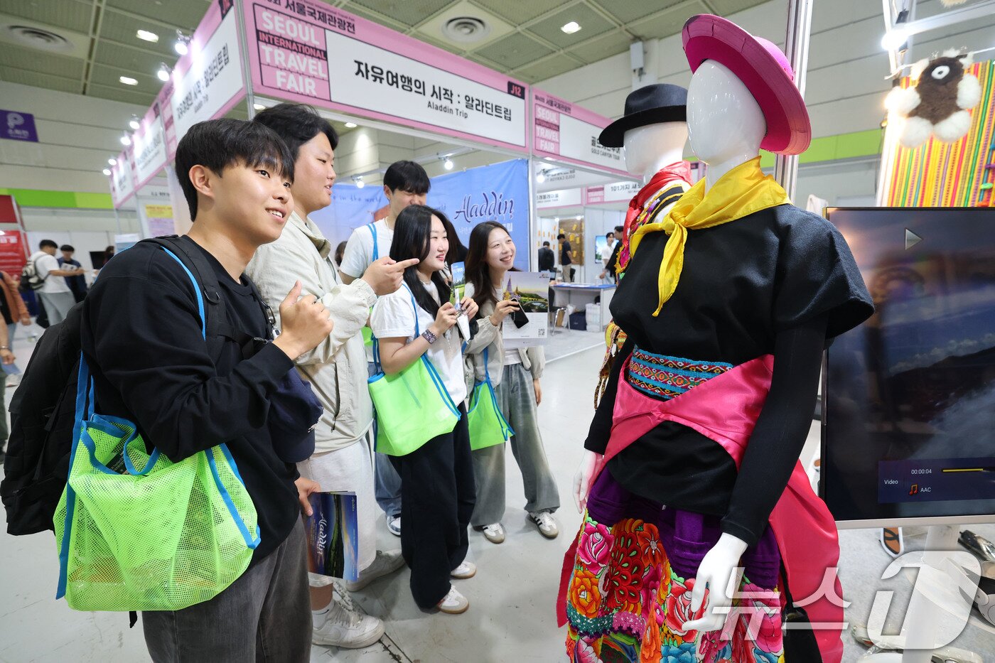 본문 이미지 - 5일 서울 강남구 코엑스에서 열린 제40회 서울국제관광전을 찾은 관람객들이 카자흐스탄 부스에서 전통복장을 살펴보고 있다. 2025.6.5/뉴스1 ⓒ News1 박세연 기자