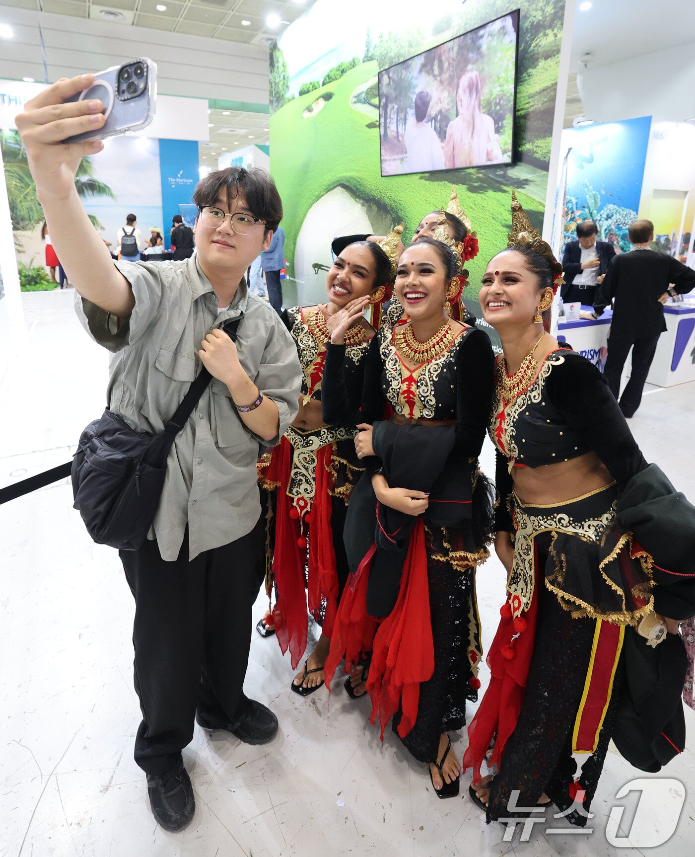 본문 이미지 - 5일 서울 강남구 코엑스에서 열린 제40회 서울국제관광전을 찾은 관람객이 스리랑카 전통복장을 입은 스리랑카관광청 직원들과 기념사진을 찍고 있다. 2025.6.5/뉴스1 ⓒ News1 박세연 기자