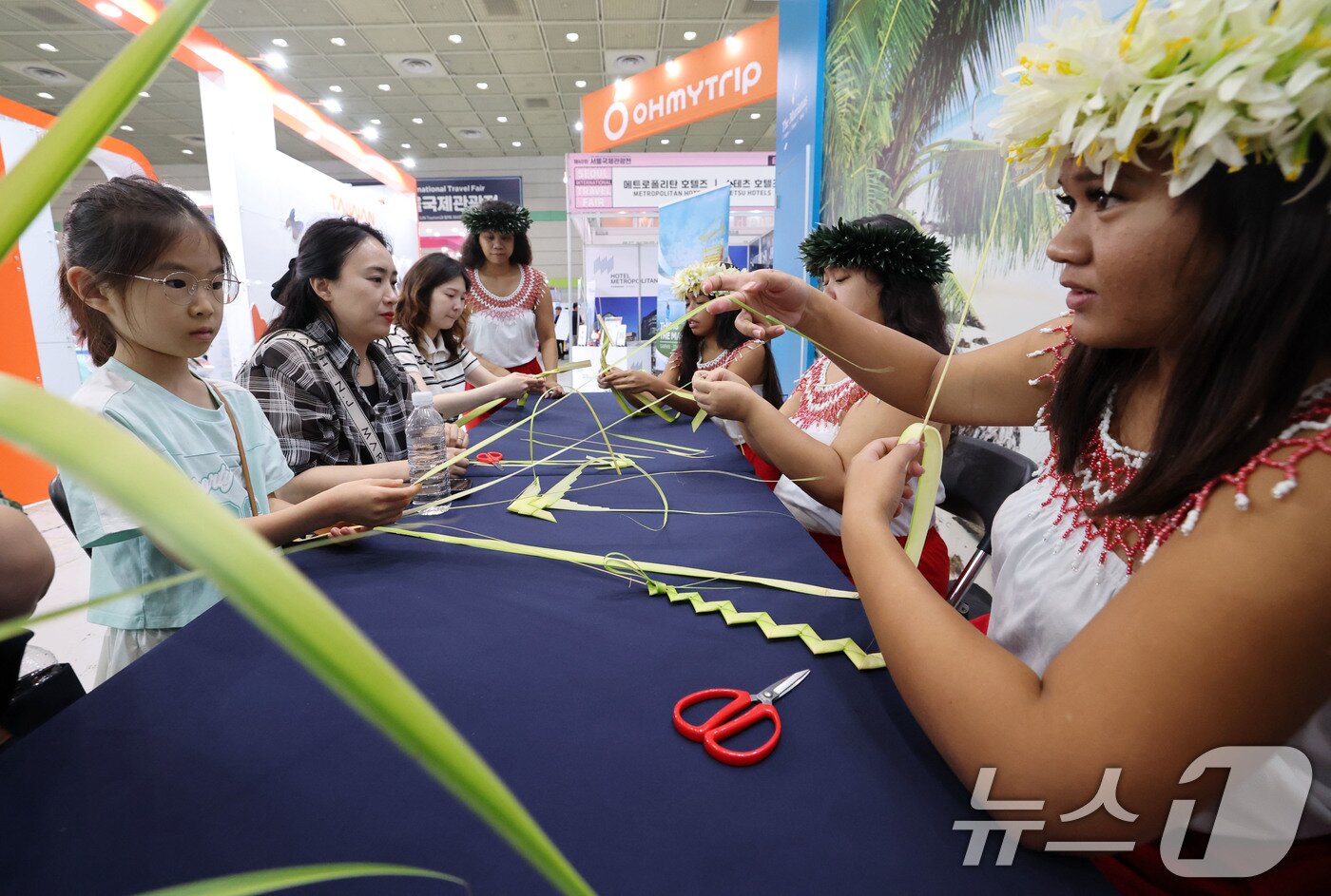 본문 이미지 - 5일 서울 강남구 코엑스에서 열린 제40회 서울국제관광전을 찾은 관람객들이 마리아나 부스에서 전통공예를 배우고 있다. 2025.6.5/뉴스1 ⓒ News1 박세연 기자